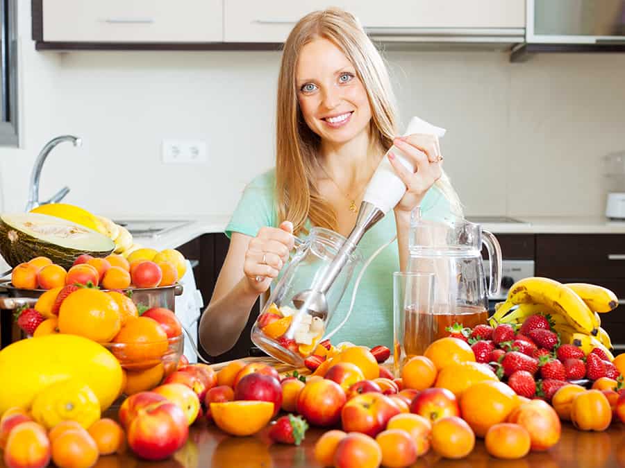 woman using the best immersion blender for the fruits