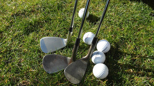 three iron golf clubs and golf balls