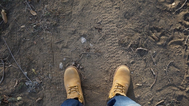 a man wearing boots on dirt ground
