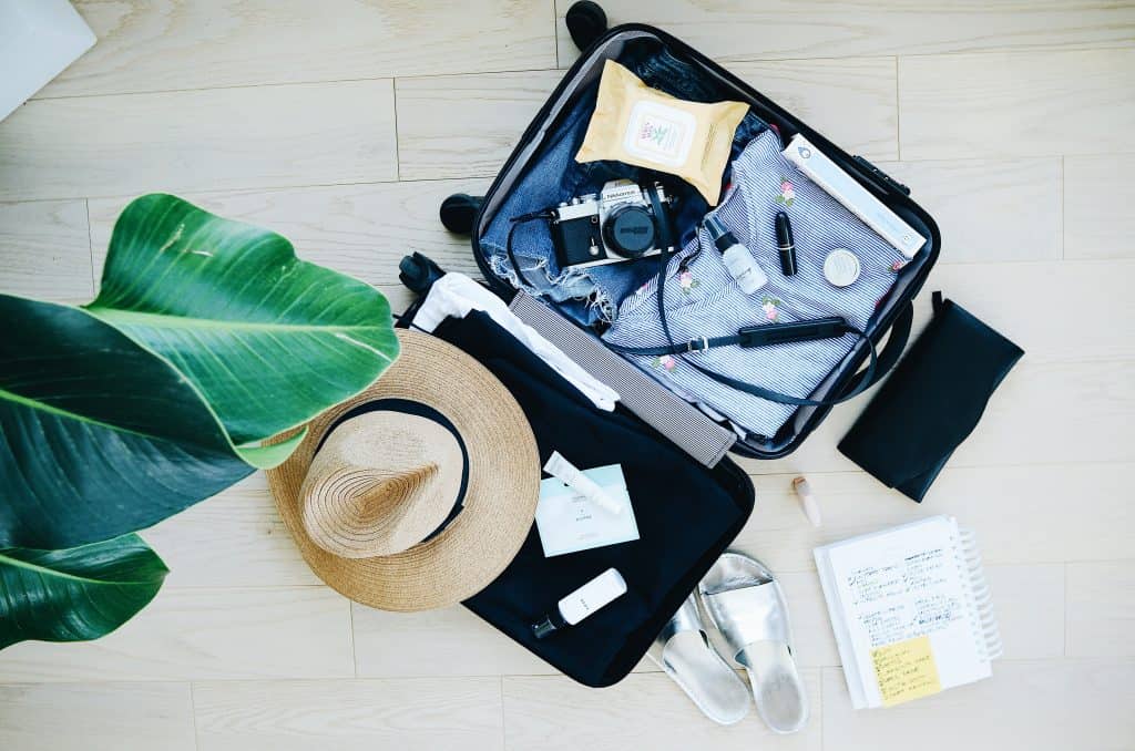 clothes and travel accessories on a suitcase