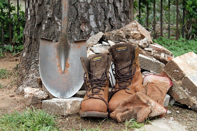 a pair of working boots, a pair of gloves and a shovel