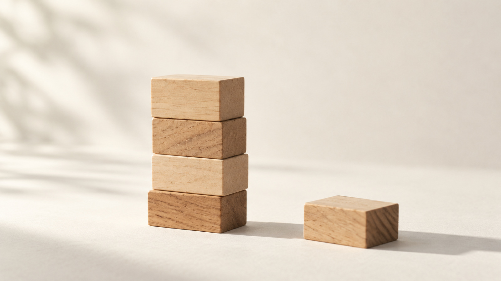 Wooden blocks stacked into a small tower with one block set aside.