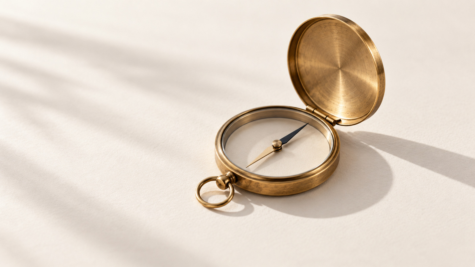 An open brass compass with its needle at rest.
